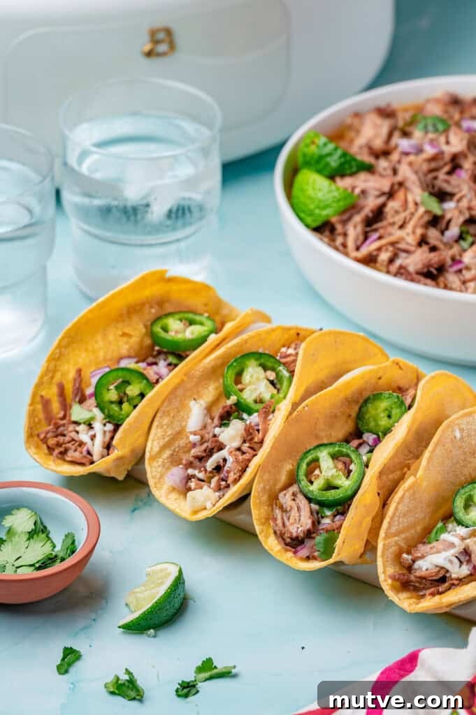 Slow Cooker Pulled Pork Tacos three tacos on a board 