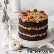 Gluten-free German chocolate cake on a round white board on a neutral linen.