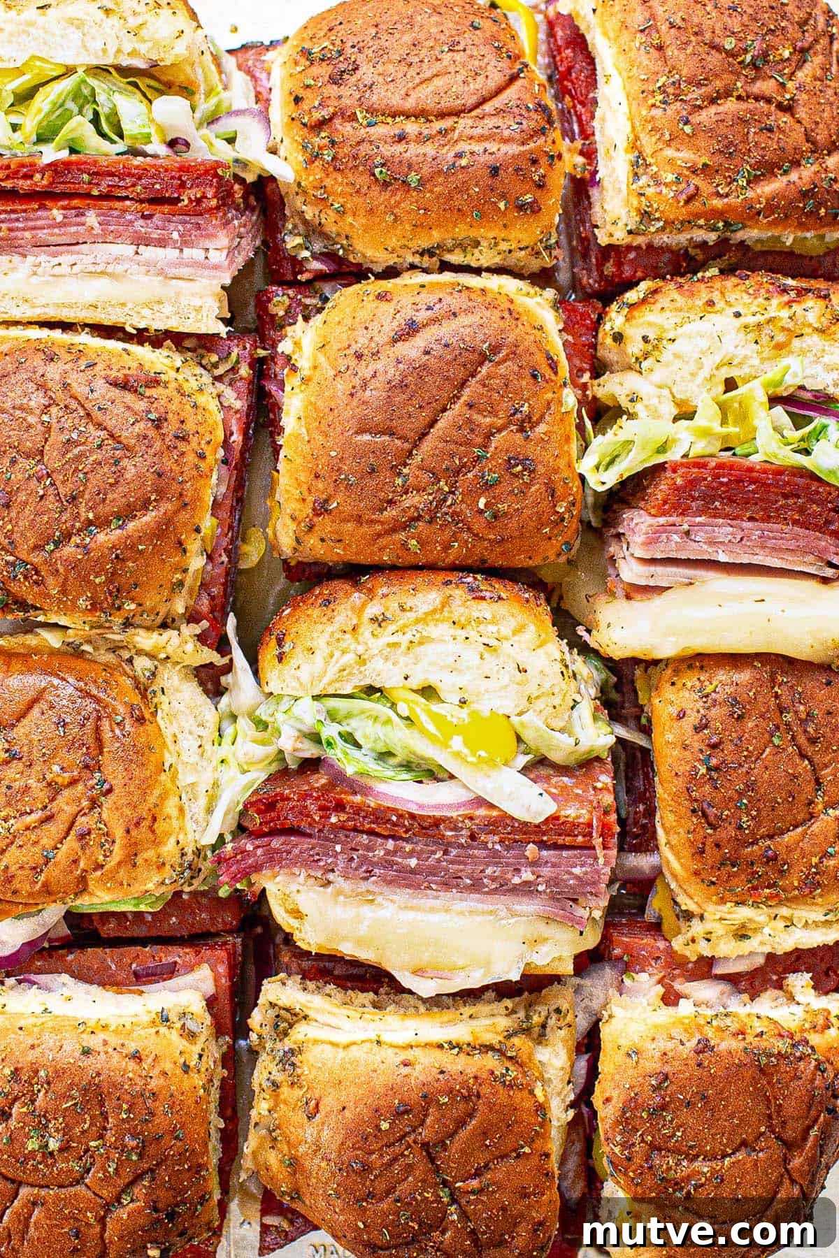 How to Make Italian Sliders with Mozzarella and Pepperoni 2 Close up of Italian sliders sliced apart with a few on their sides.