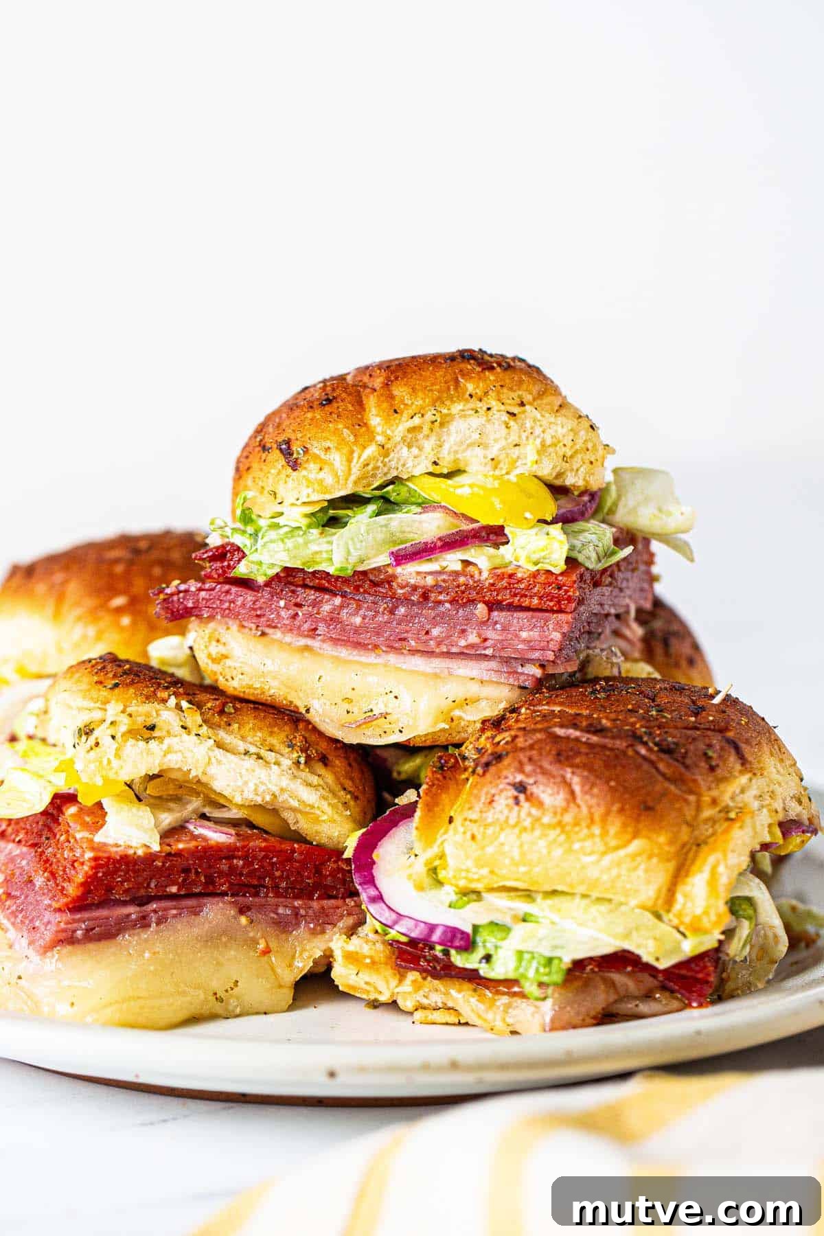 How to Make Italian Sliders with Mozzarella and Pepperoni 7 Italian sliders cut apart and stacked on a serving platter.