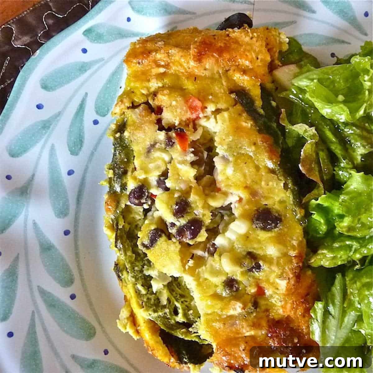Egg Bake Chili Rellenos serving - 600 A serving of chile rellenos breakfast casserole on a plate with a salad.