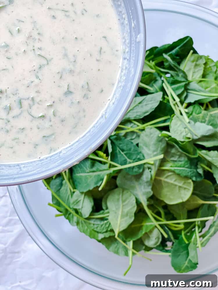 process shot showing adding dressing to kale