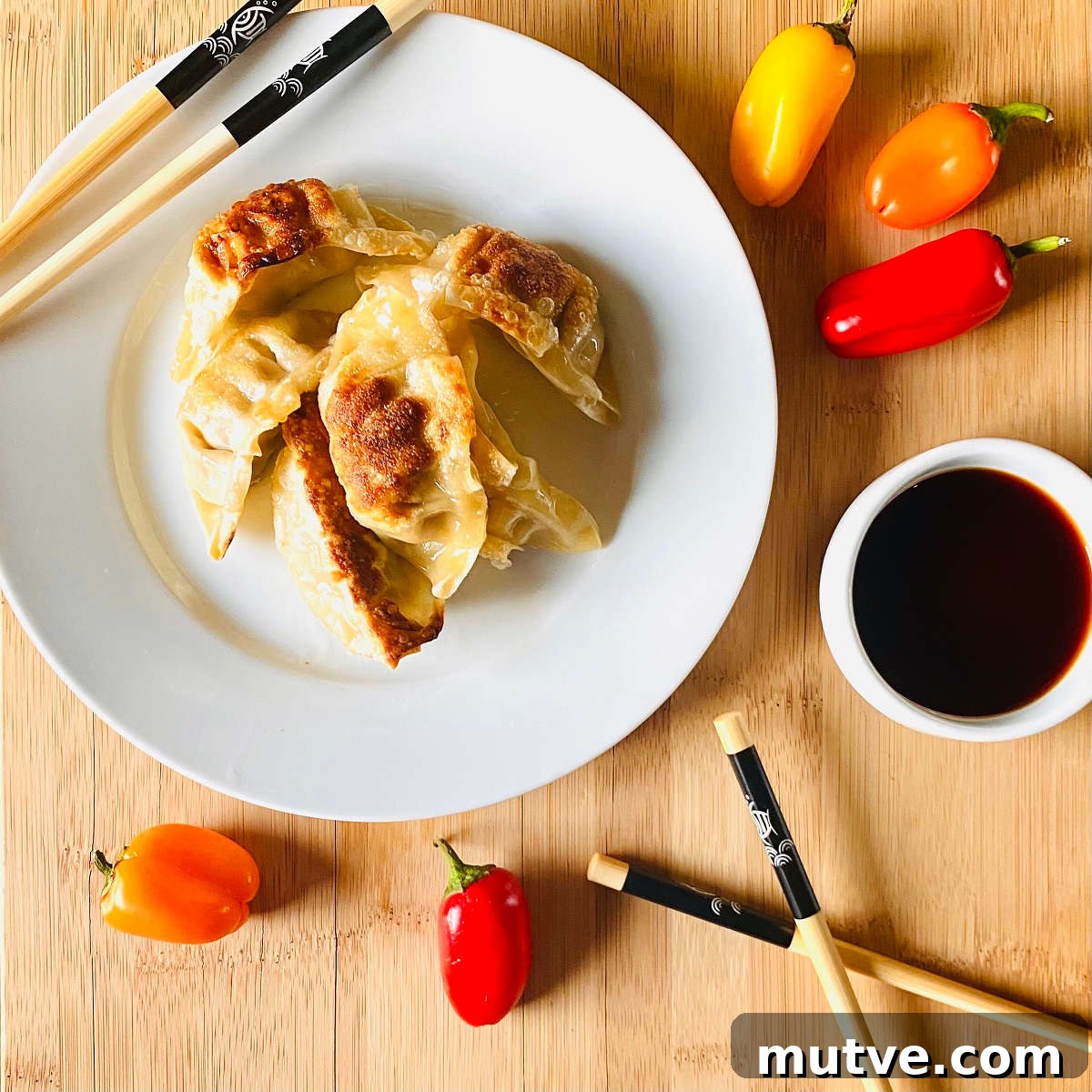 Crispy Air Fryer Frozen Dumplings: Gyoza and Potstickers 6 air fryer gyoza potstickers on a plate with chopsticks and soy sauce