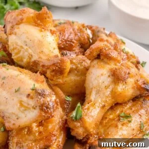 Extra Crispy Oven-Baked Chicken Wings Recipe 10 a plate of oven-baked chicken wings garnished with parsley.