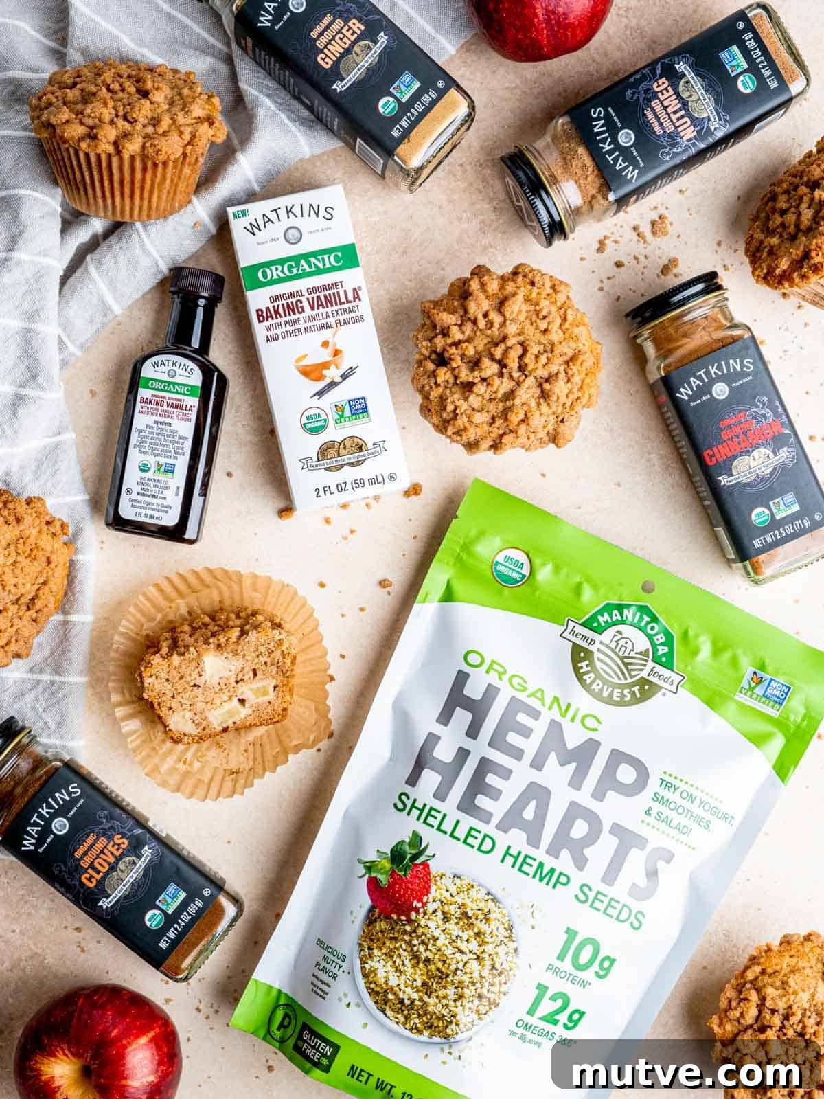 Apple Streusel Muffins Recipe with Cinnamon Crumble 5 Top view of apple streusel muffins, Watkins baking vanilla, and Manitoba Harvest hemp hearts