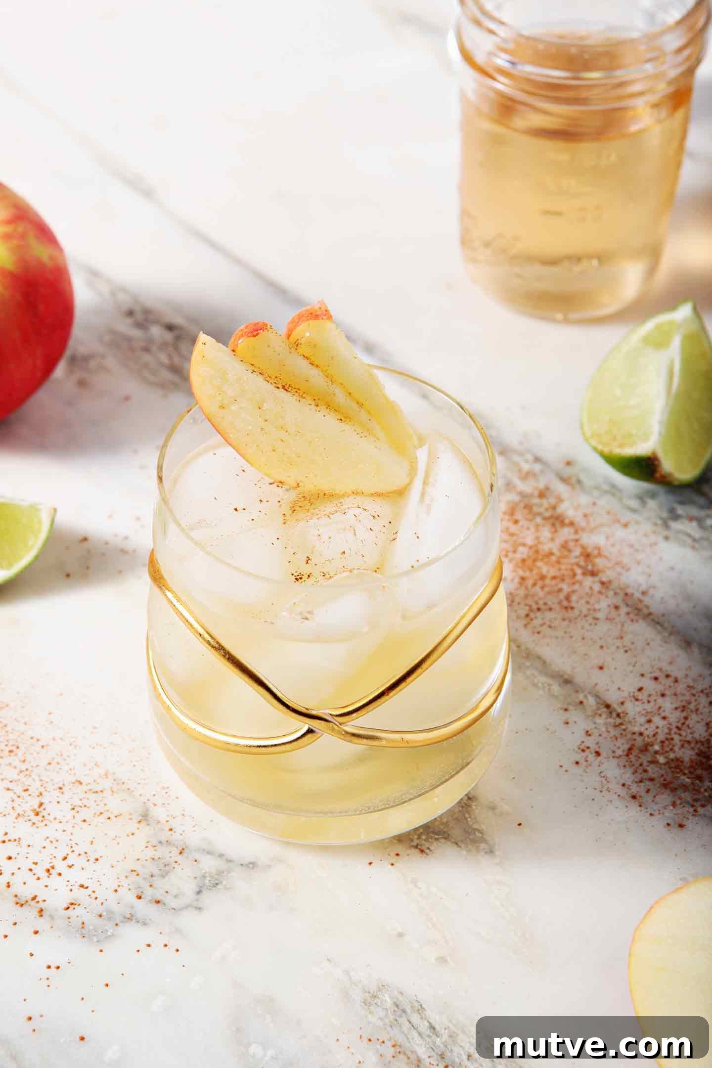 Apple Cider Moscow Mule Cocktail Recipe 9 A Apple Pie Moscow Mule sits on a marble background, surrounded by apples and lime slices