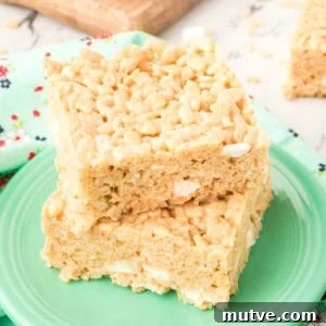 Browned Butter Rice Krispie Treats 18 Square crop of two thick, gooey Browned Butter Rice Crispy Treats stacked on a green plate with visible marshmallow pockets.