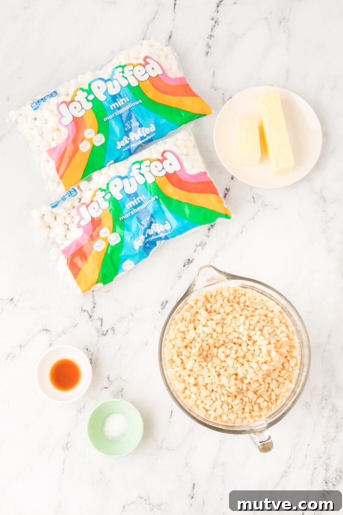Browned Butter Rice Krispie Treats 3 Ingredients for Browned Butter Rice Crispy Treats including mini marshmallows, butter sticks, crispy rice cereal, vanilla extract, and salt on a marble surface.