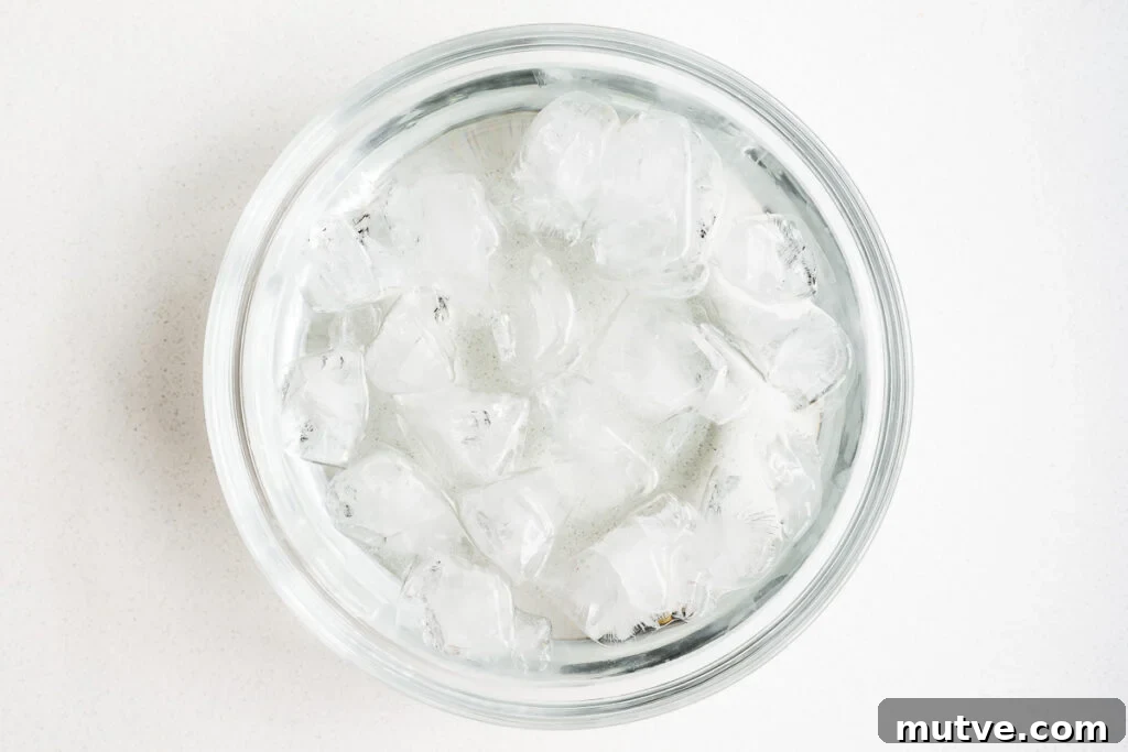 Mayak Eggs Recipe: Korean Soy-Marinated Ramen Eggs 5 An ice bath in a glass mixing bowl.