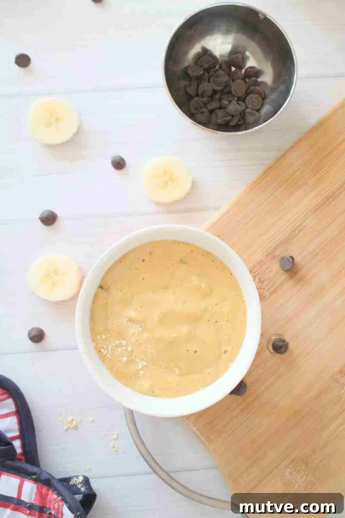 3-Ingredient Dairy-Free Protein Mug Cake 6 White bowl with raw mug cake in it on a cutting board.