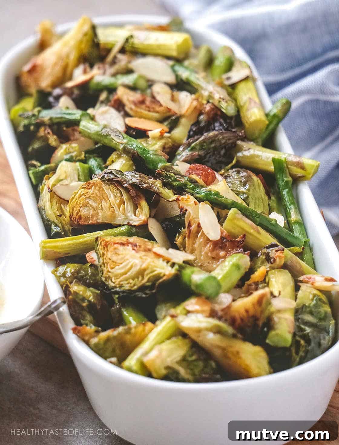 Healthy Brussels Sprouts and Asparagus Recipe to serve as a side dish or dinner. This easy oven roasted Brussels sprouts recipe with asparagus and toasted almonds – all crispy served with a sweet and tangy mustard sauce. 