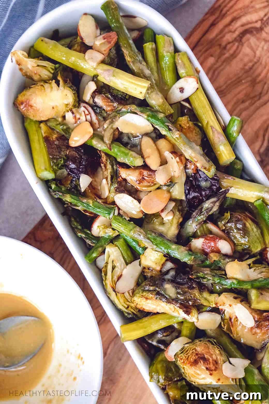Crispy oven roasted Brussels sprouts asparagus and toasted almonds baked to perfect golden brown and served with a maple lemon Dijon mustard sauce for an extra kick.