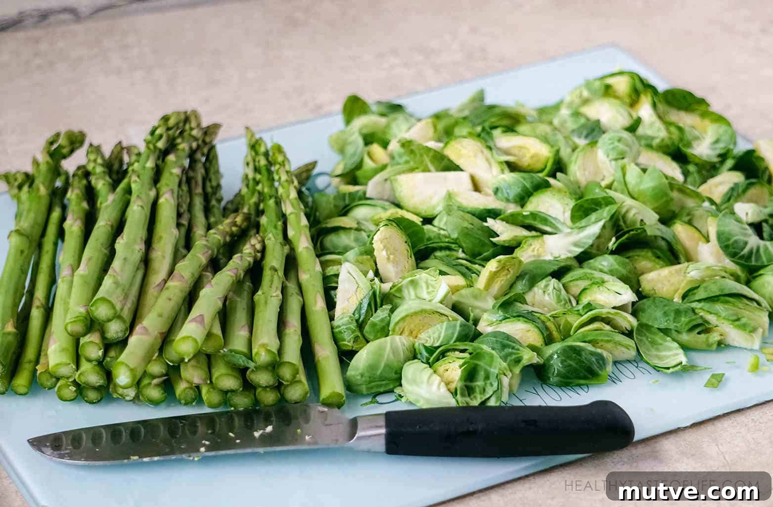 Chopped quartered brussels sprouts and asparagus prepared for roasting