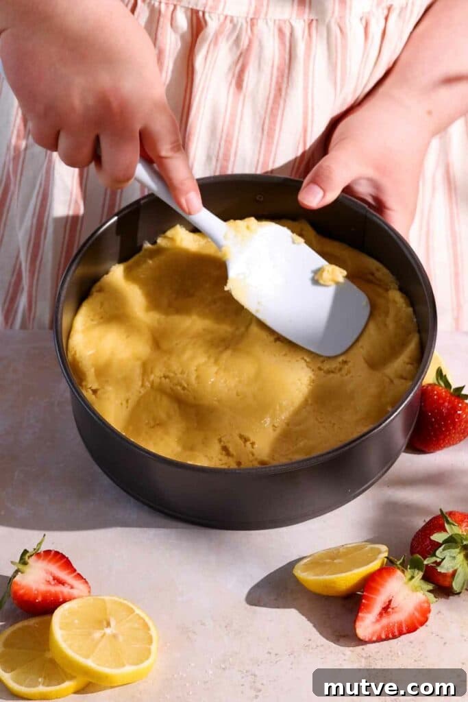 spreading cake batter into bottom of pan