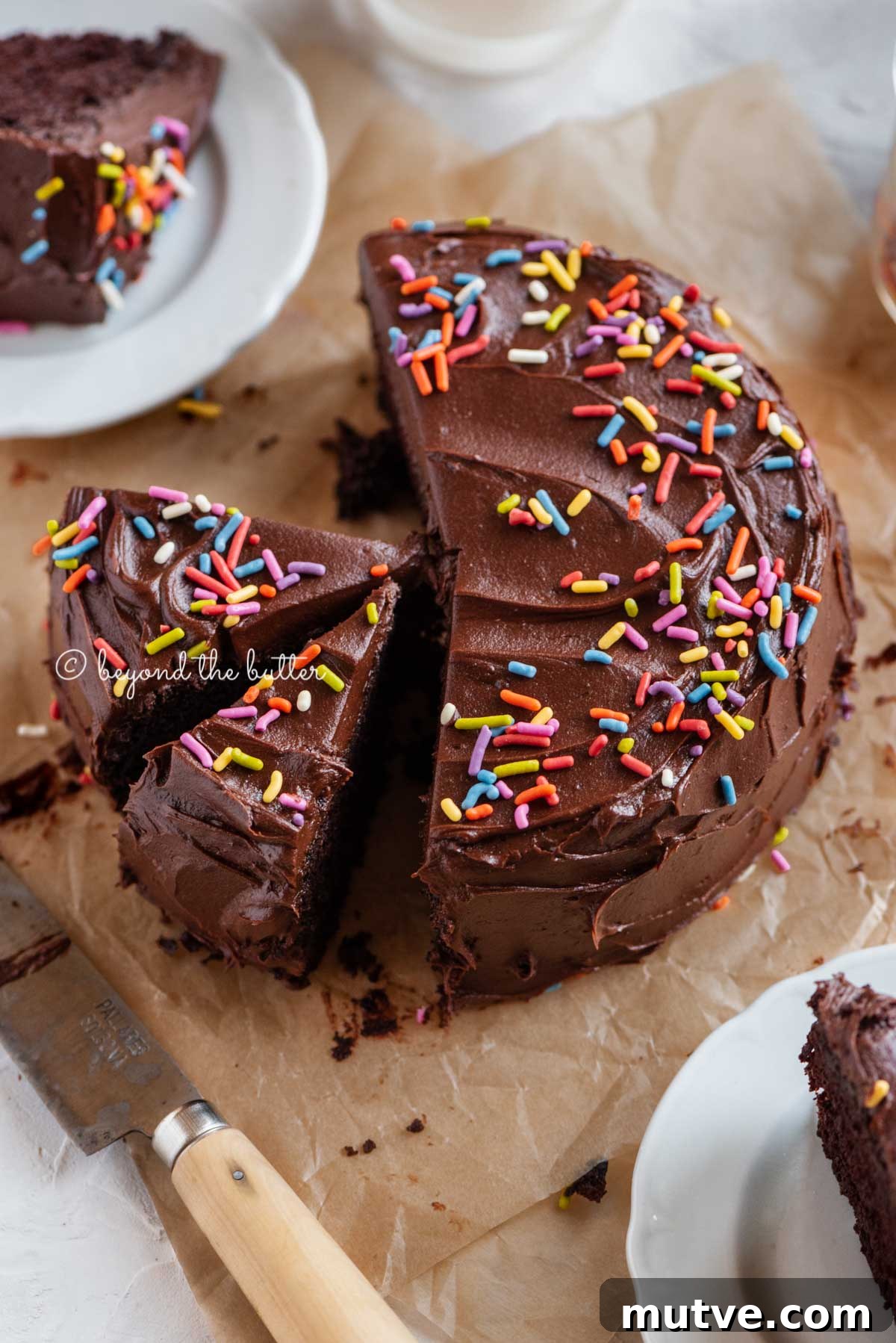 Moist Single-Layer Chocolate Cake Recipe 2 Angled image of sliced single layer chocolate cake on parchment paper | All Images © Beyond the Butter™