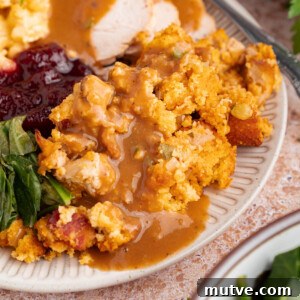 Classic Southern Cornbread Dressing 11 Cornbread dressing on a plate with turkey, cranberry sauce, greens and mashed potatoes.