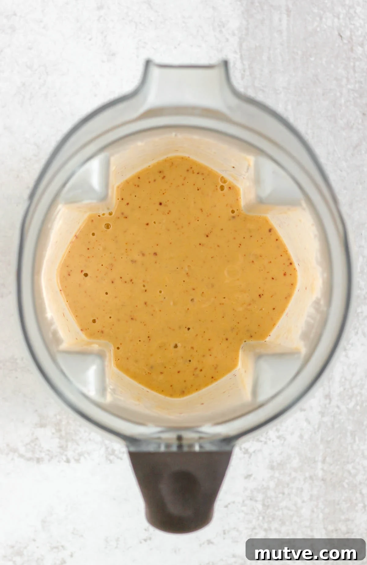 Blended peach banana smoothie in a blender.