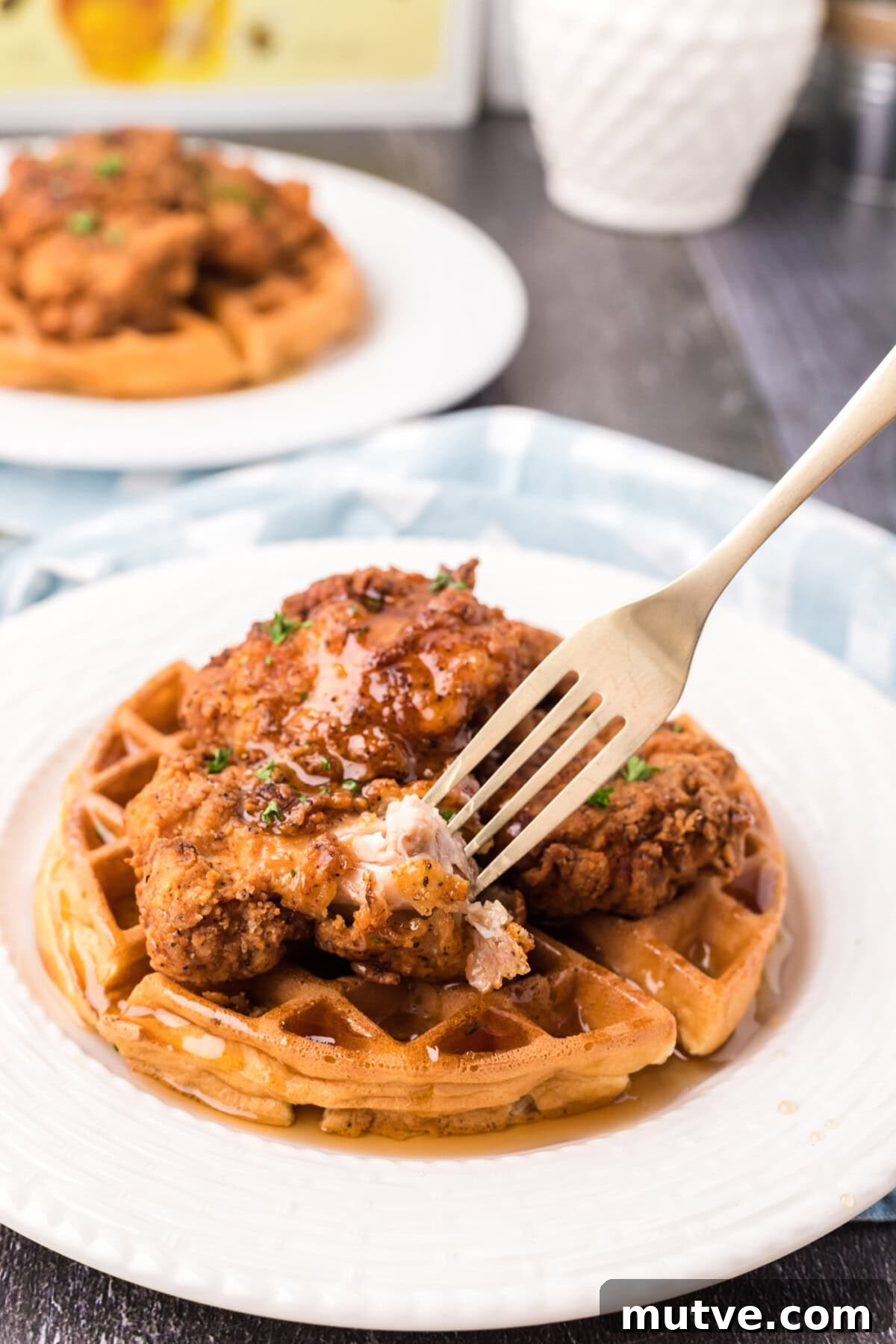 Crispy Chicken and Waffles Recipe with Maple Syrup 11 Fork taking a piece of Chicken and Waffles