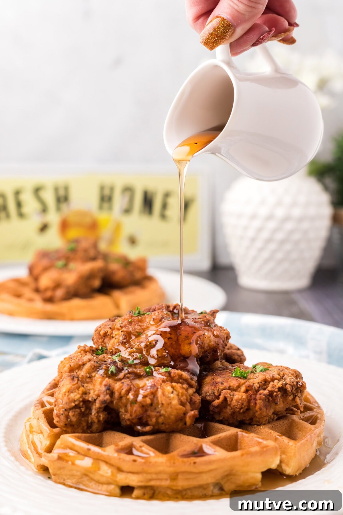 Crispy Chicken and Waffles Recipe with Maple Syrup 3 Syrup being drizzled over a plate of Chicken and Waffles