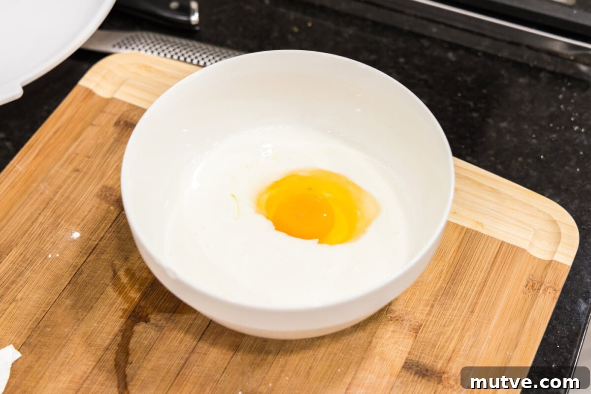 Crispy Chicken and Waffles Recipe with Maple Syrup 5 egg and buttermilk in a bowl