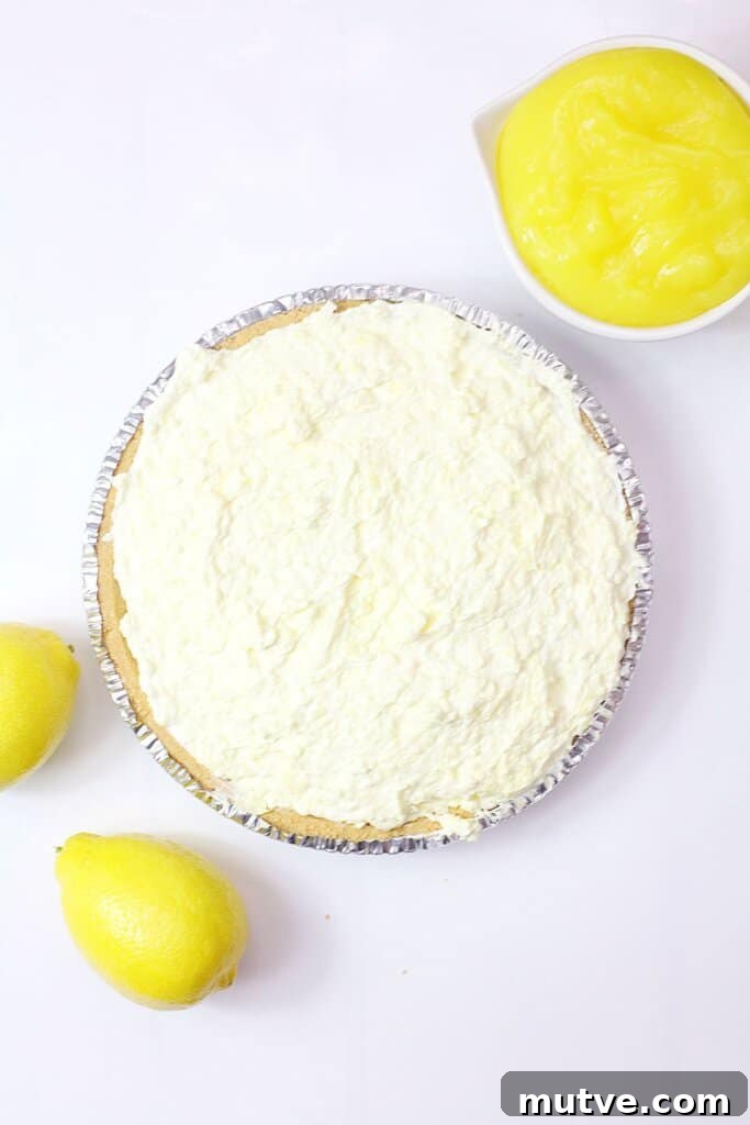 lemon pie filling being spread on top of a pie crust.