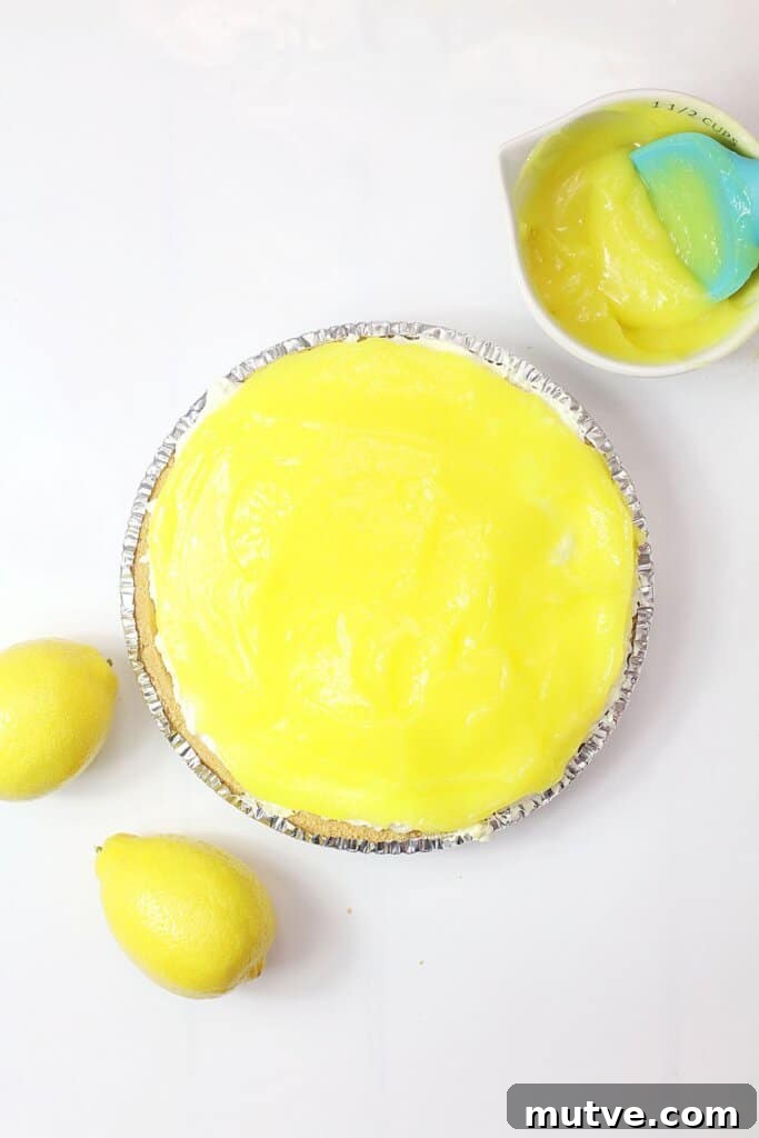 lemon pie filling being spread on top of a pie crust.