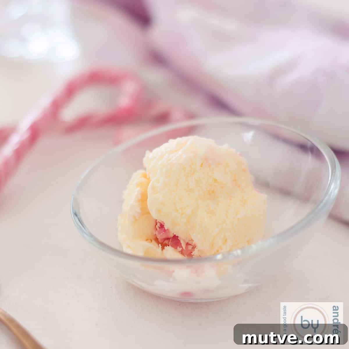 Showstopping Christmas Dessert Recipes 4 A glass bowl with a ball of candy cane ice cream. Some candy canes in the back