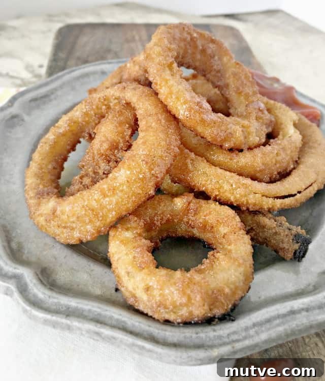 Crispy Frozen Onion Rings: Oven, Air Fryer and Skillet 2 grey plate on a cutting board with crispy onion rings