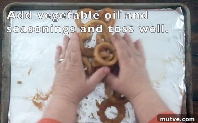 Crispy Frozen Onion Rings: Oven, Air Fryer and Skillet 6 two hands tossing onion rings, oil and seasonings on a baking sheet