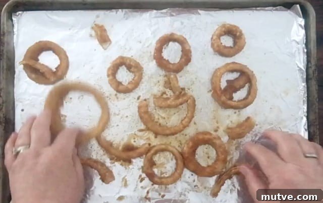 Crispy Frozen Onion Rings: Oven, Air Fryer and Skillet 7 hands spreading the onion rings out for baking